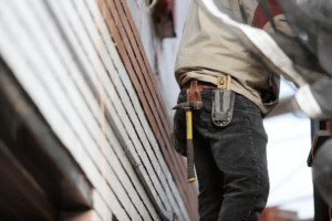 man met hamer op holster van werkbroek